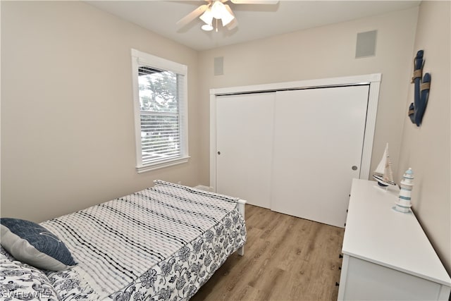 bedroom with ceiling fan, a closet, and light hardwood / wood-style flooring