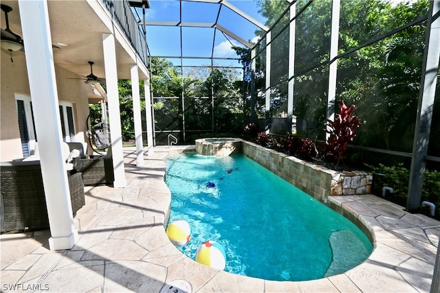 view of swimming pool with ceiling fan, an in ground hot tub, a lanai, and a patio area