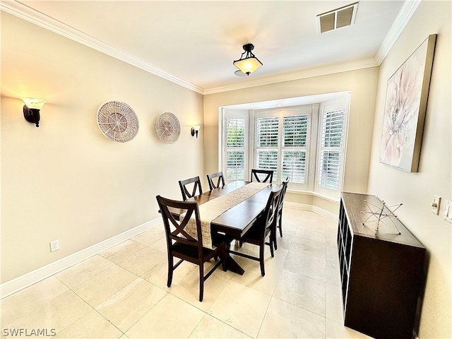 dining area with ornamental molding and light tile flooring