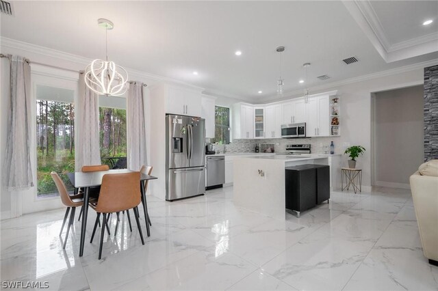 kitchen featuring white cabinets, decorative light fixtures, a center island, and appliances with stainless steel finishes