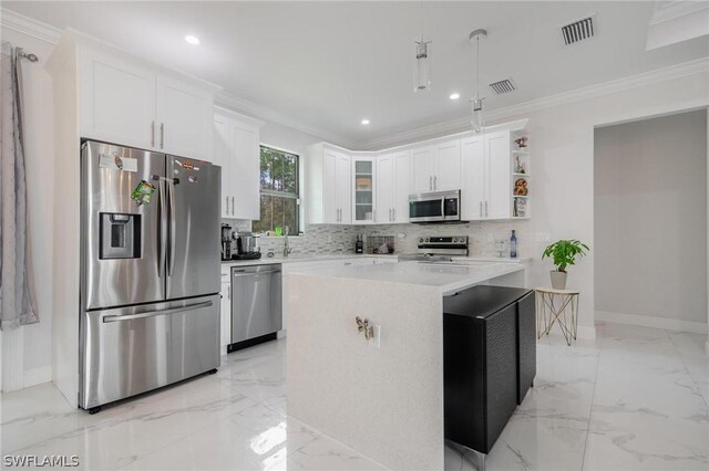 kitchen featuring white cabinets, a center island, ornamental molding, and stainless steel appliances