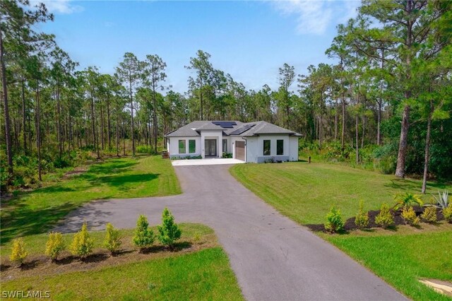 view of front of house featuring a front lawn and solar panels