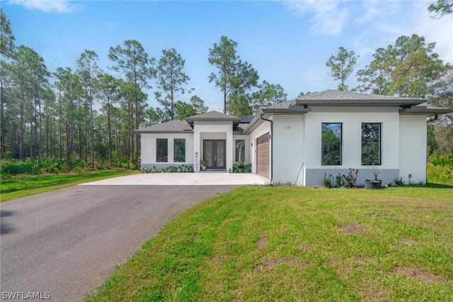 prairie-style home featuring french doors, a garage, and a front lawn