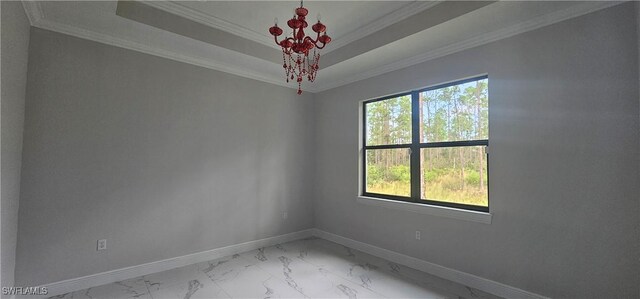 empty room with a raised ceiling and crown molding