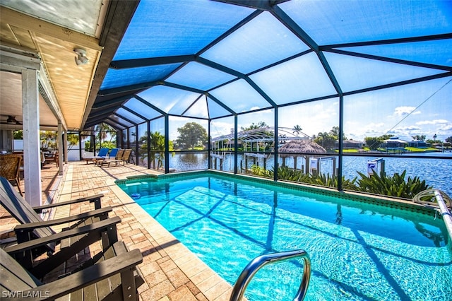 view of swimming pool with glass enclosure, a patio area, and a water view