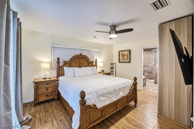 bedroom with hardwood / wood-style flooring, ceiling fan, and ensuite bath