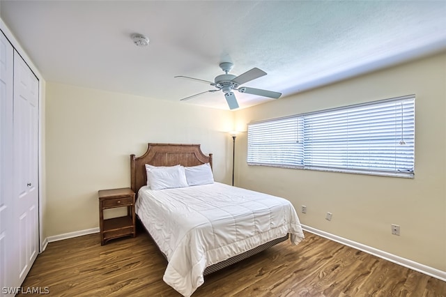 bedroom featuring ceiling fan, dark wood-type flooring, and a closet