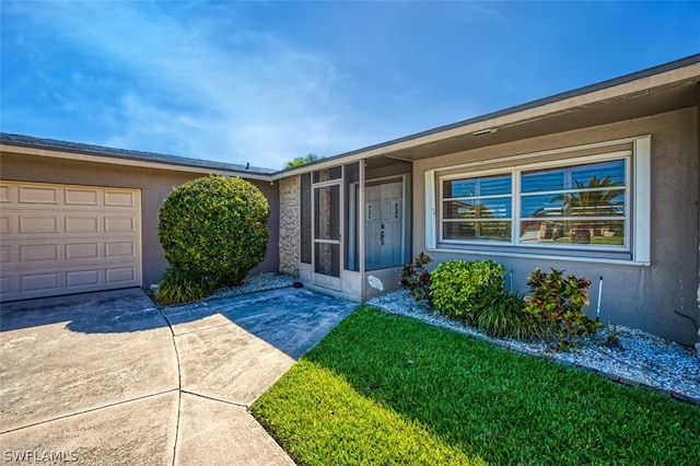 entrance to property with a yard and a garage