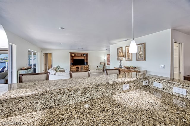 kitchen with decorative light fixtures and light stone countertops