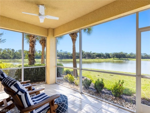 unfurnished sunroom with ceiling fan, a water view, and plenty of natural light