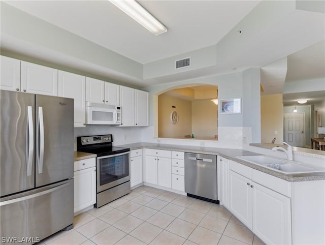 kitchen with kitchen peninsula, appliances with stainless steel finishes, and white cabinets