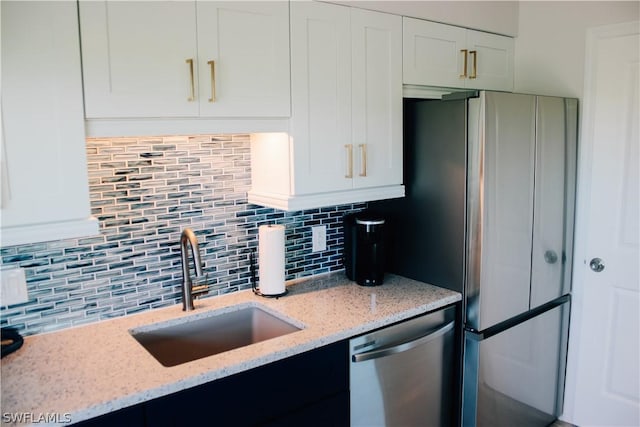 kitchen featuring white cabinetry, sink, light stone countertops, and appliances with stainless steel finishes