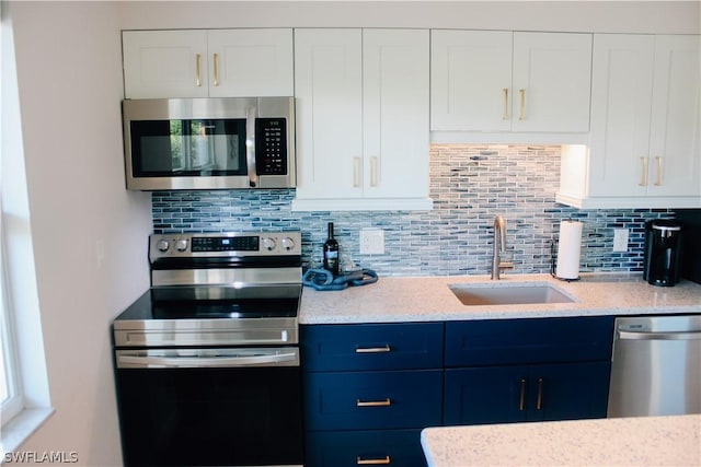 kitchen featuring tasteful backsplash, appliances with stainless steel finishes, sink, and white cabinets