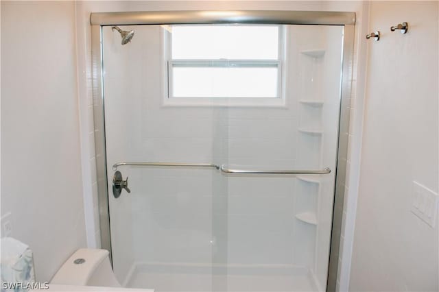 bathroom with toilet and an enclosed shower