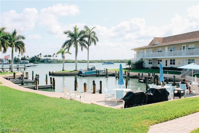 view of dock with a water view and a yard