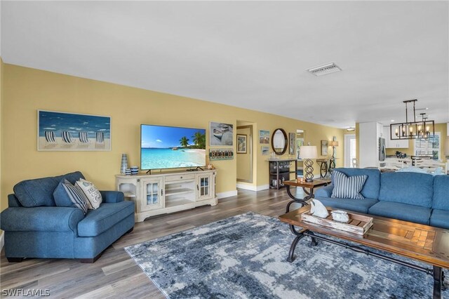 living room with hardwood / wood-style floors and a chandelier