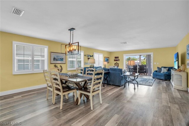 dining room with wood-type flooring and a chandelier