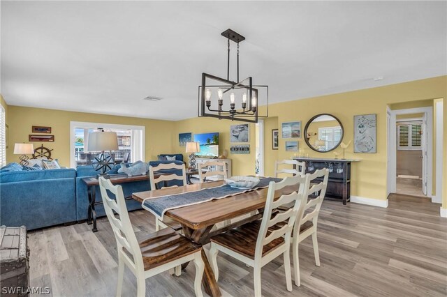 dining space with an inviting chandelier and light wood-type flooring