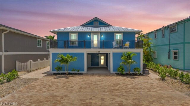 back house at dusk with a balcony