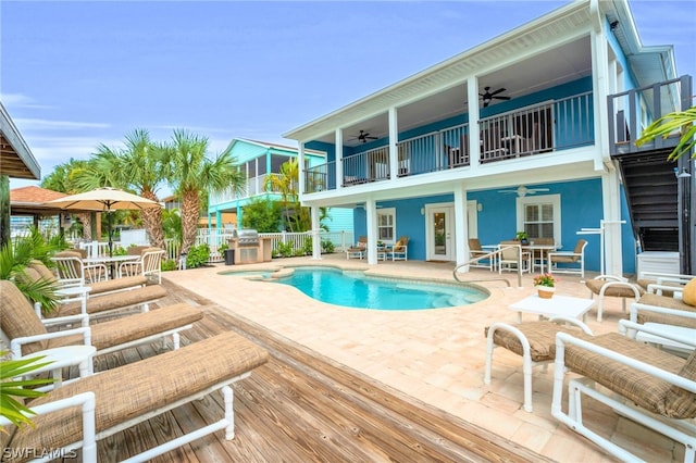 view of swimming pool featuring grilling area, ceiling fan, and a patio area