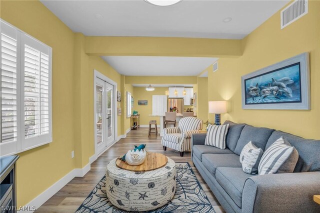 living room featuring beam ceiling and light wood-type flooring