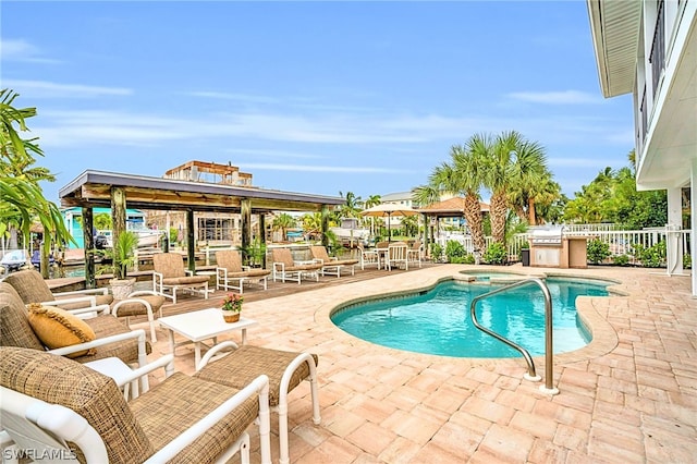 view of swimming pool featuring a grill, an in ground hot tub, and a patio