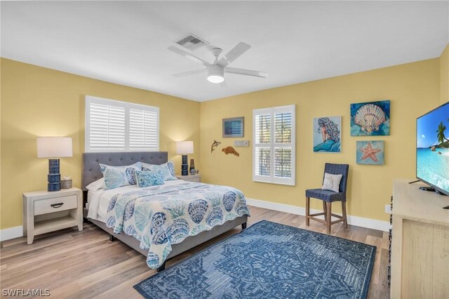 bedroom with multiple windows, light hardwood / wood-style flooring, and ceiling fan