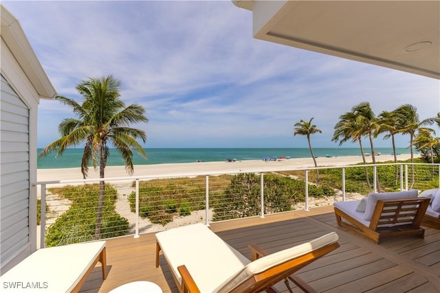 balcony featuring a view of the beach and a water view