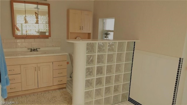 bathroom with backsplash, sink, and tile patterned flooring