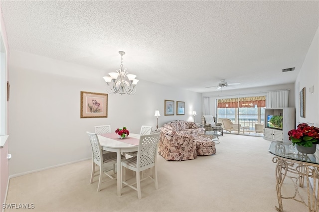 dining room featuring light carpet, a textured ceiling, and ceiling fan with notable chandelier