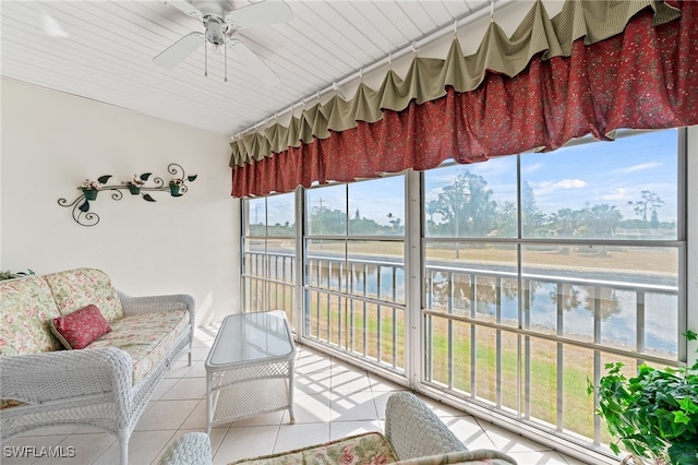 sunroom with ceiling fan, a water view, and a healthy amount of sunlight