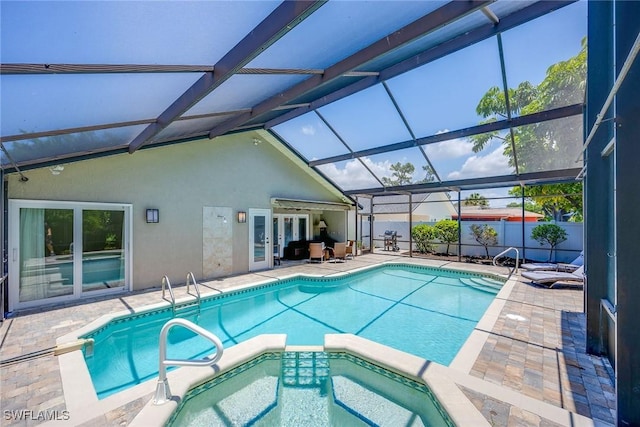 view of swimming pool featuring an in ground hot tub, glass enclosure, and a patio