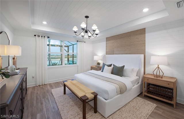 bedroom featuring a notable chandelier, a tray ceiling, wooden ceiling, and dark hardwood / wood-style floors