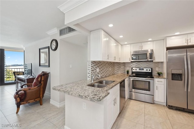 kitchen featuring a sink, decorative backsplash, light stone counters, and appliances with stainless steel finishes