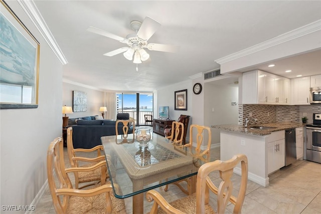 dining space with ceiling fan, baseboards, visible vents, and ornamental molding