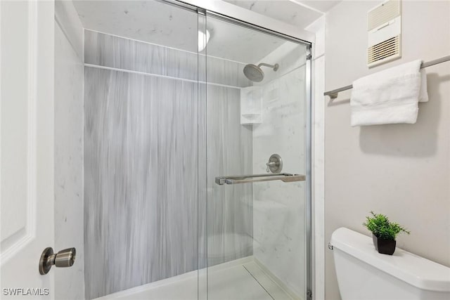 bathroom with toilet, visible vents, and a stall shower