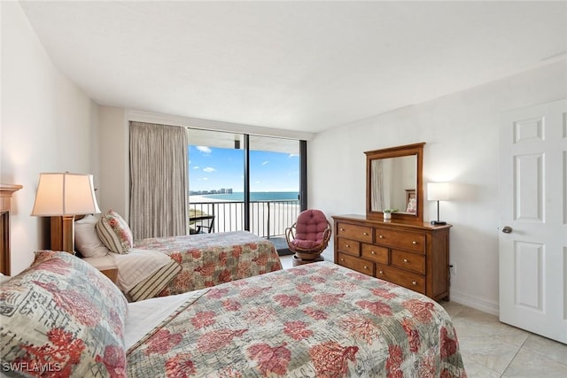 bedroom with a water view, expansive windows, light tile patterned floors, baseboards, and access to exterior