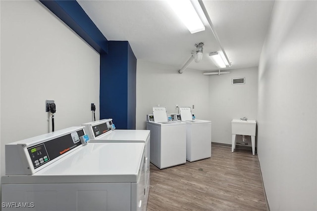 common laundry area with visible vents, light wood finished floors, a ceiling fan, and washing machine and clothes dryer