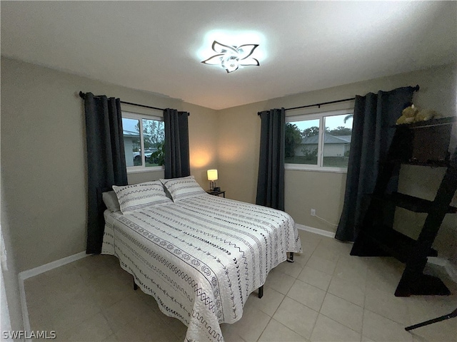 bedroom featuring light tile patterned floors and multiple windows