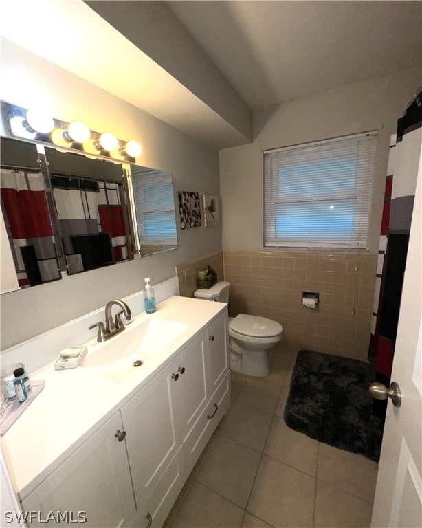 bathroom featuring tile patterned flooring, toilet, tile walls, and vanity