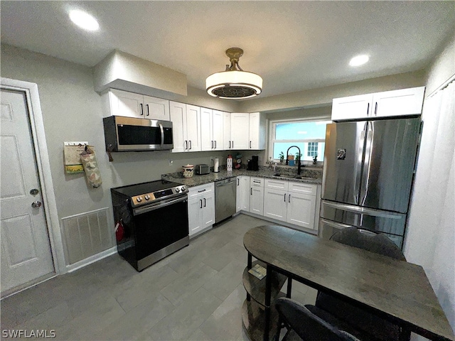 kitchen featuring appliances with stainless steel finishes, sink, and white cabinetry