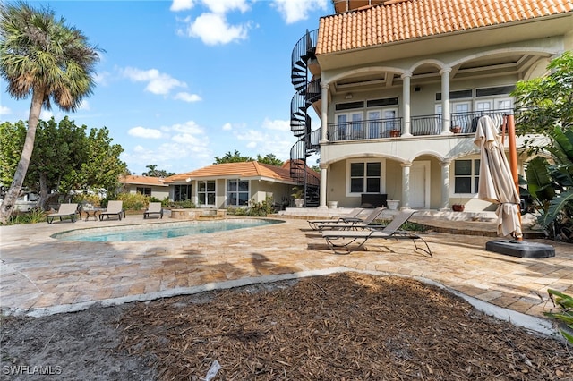 rear view of property with a patio and a balcony