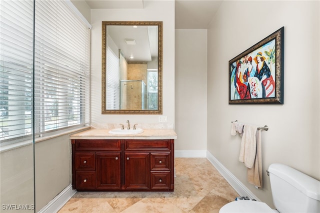 bathroom featuring vanity, toilet, and a shower with door