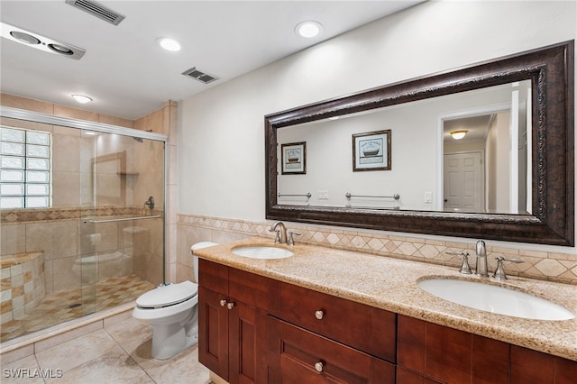 bathroom featuring tile walls, vanity, an enclosed shower, toilet, and tile patterned floors