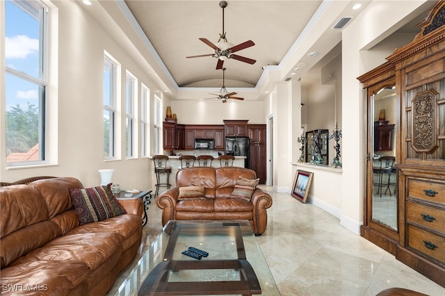 living room featuring ceiling fan, vaulted ceiling, and a wealth of natural light