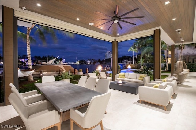 patio terrace at dusk featuring outdoor lounge area and ceiling fan