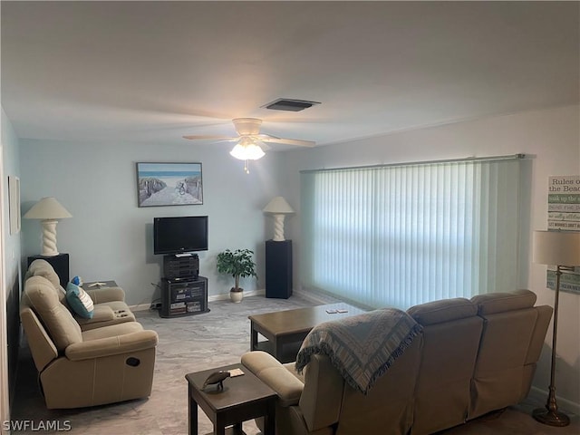 living area featuring baseboards, visible vents, and a ceiling fan