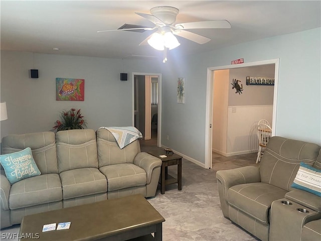 living room featuring a ceiling fan and baseboards