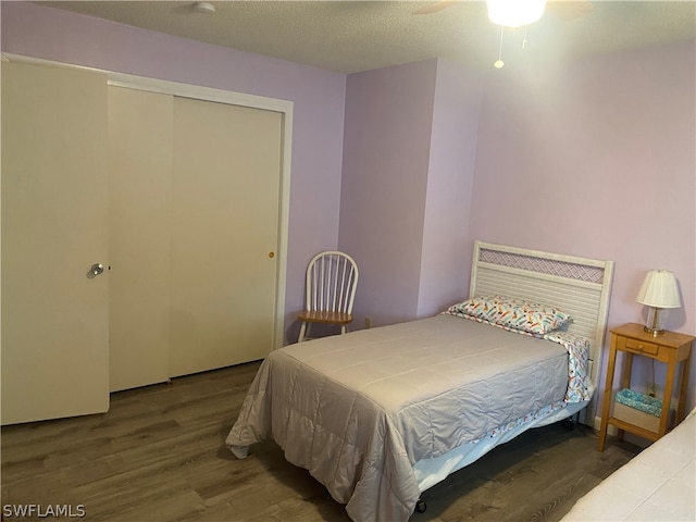 bedroom with ceiling fan, a closet, a textured ceiling, and hardwood / wood-style flooring