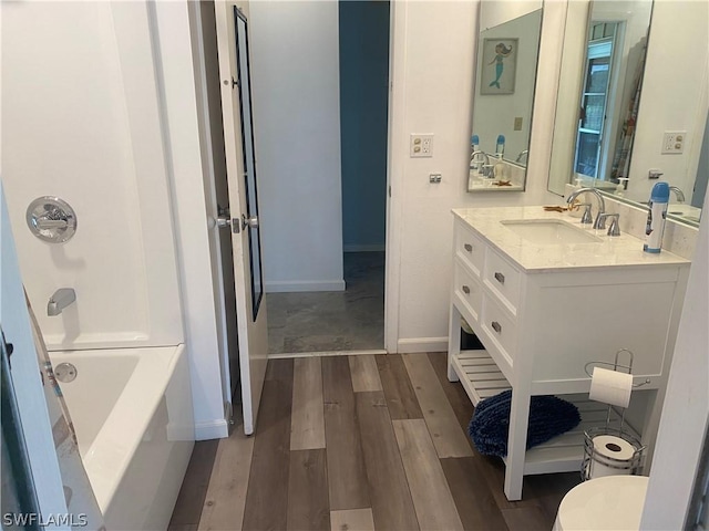 full bath with shower / bathing tub combination, wood finished floors, vanity, and baseboards